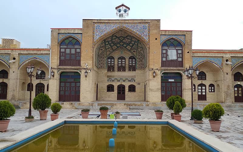 حیاط حوض دار در مسجدی با ایوانی بلند