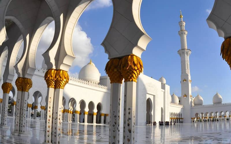 مسجدی بزرگ و سفیدرنگ با ستون های تزیین شده و گنبد و مناره
