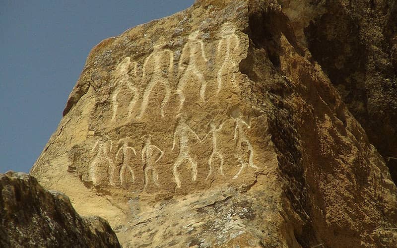 سنگ سنگاره هایی به شکل انسان روی صخره ای بزرگ
