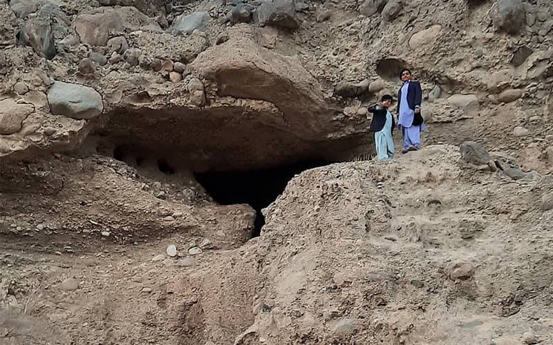 دو کودک با لباس بلوچی در دهانه غار