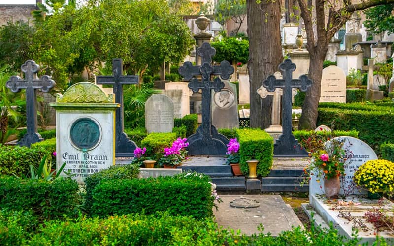 قبرستانی با سنگ قبرهای ایستاده در محیطی سرسبز
