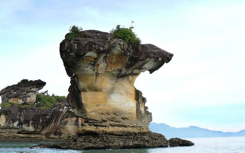 صخره بزرگ و عمودی در دریا و کنار ساحل