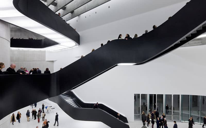 تعداد زیادی بازدیدکننده در طبقه همکف و پلکان موزه ملی هنر قرن ۲۱