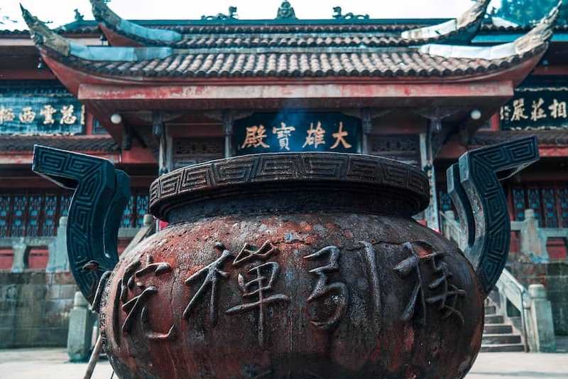 ظرف سنگی بزرگی با نوشته های چینی در مقابل ساختمانی قدیمی