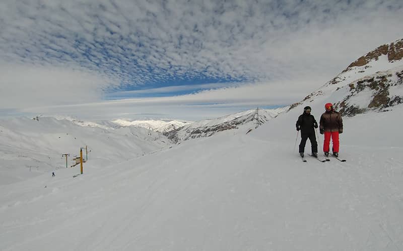 دو اسکی باز در ارتفاعات پوشیده از برف