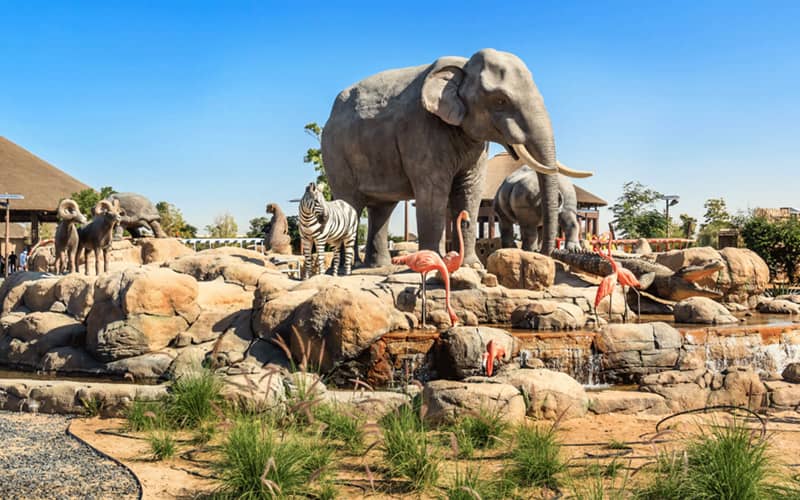 تعداد زیادی لک لک در اطراف مجسمه فیلی بزرگ در سافاری پارک دبی