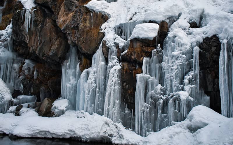 آبشاری یخ زده در زمستان برفی