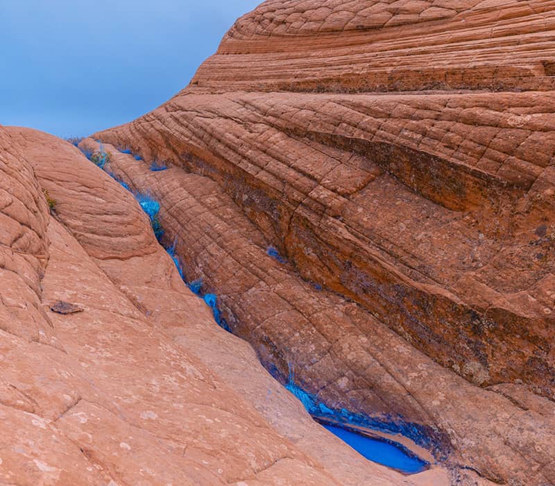 جریان رودخانه ای آبی رنگ در میان صخره ها
