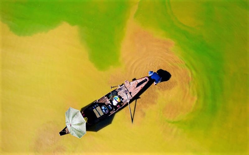 عکس هوایی از قایقی در آب‌های رنگارنگ