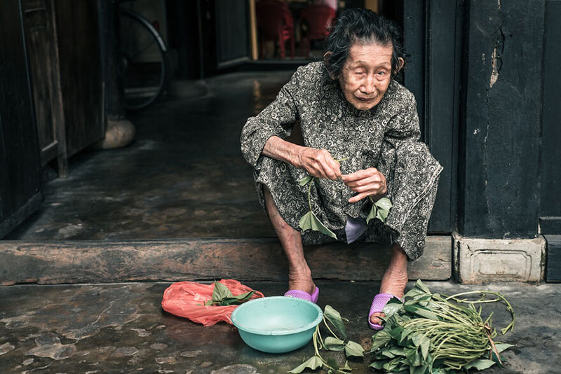 زنی در حال پاک کردن سبزی در ویتنام