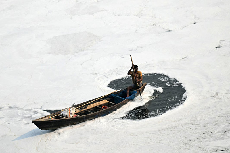یک قایقران در آب‌های آلوده رودخانه یامونا در هند