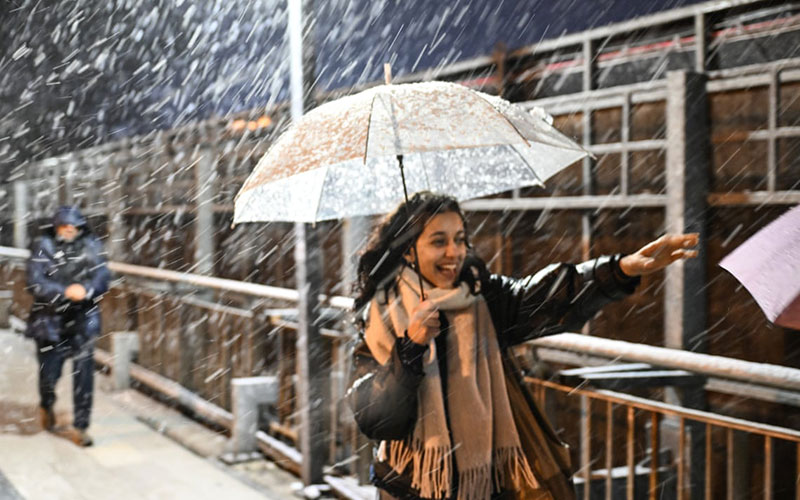 زنی زیر چتر در اولین برف فصل در استانبول ترکیه