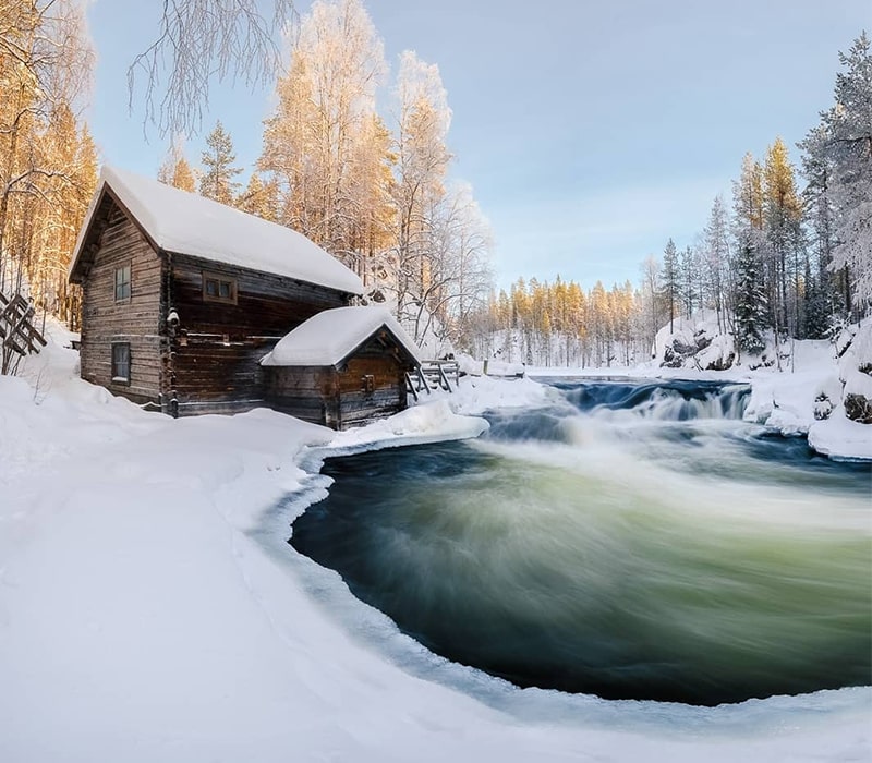 کلبه چوبی در کنار رودخانه‌ای در فنلاند