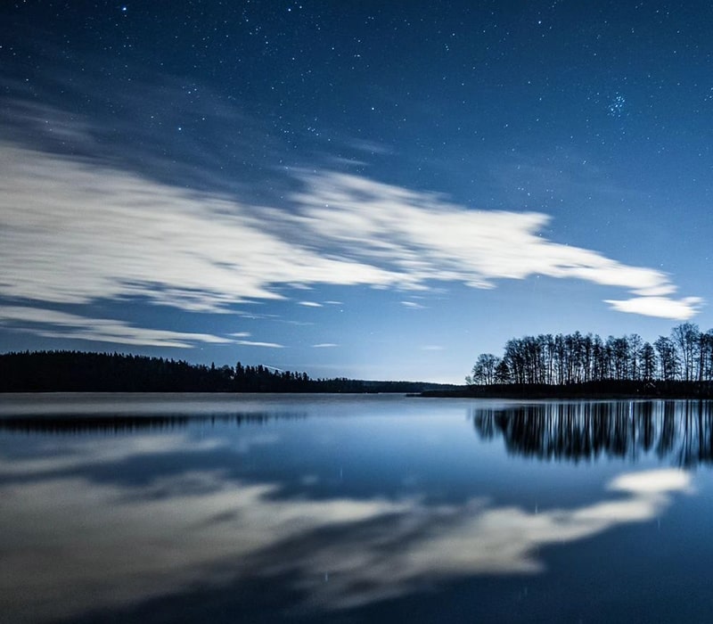 انعکاس تصویر آسمان در دریاچه‌ای در فنلاند