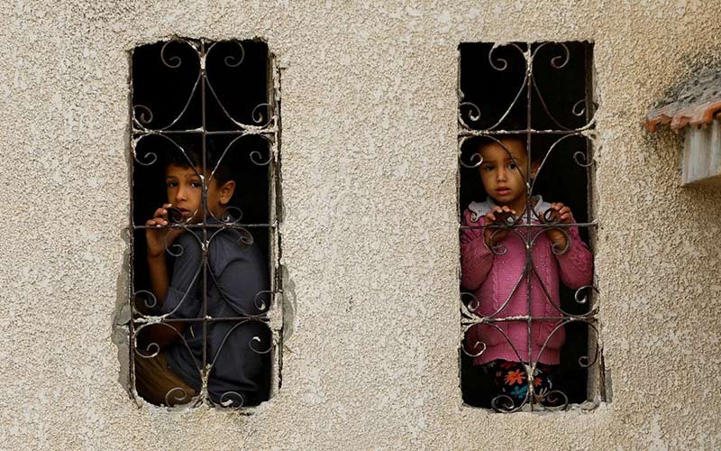 کودکان فلسطینی پشت پنجره‌ای در خان یونس در جنوب نواز غزه