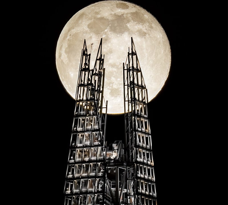 ماه کامل از پشت سازه‌ای فلزی در بریتانیا