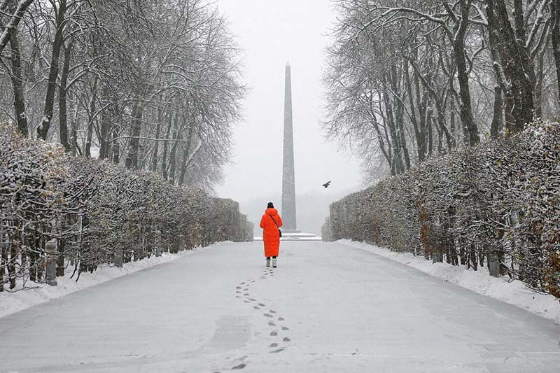 یک زن در پارک پوشیده از برف در اولین بارش برف در کیف اوکراین