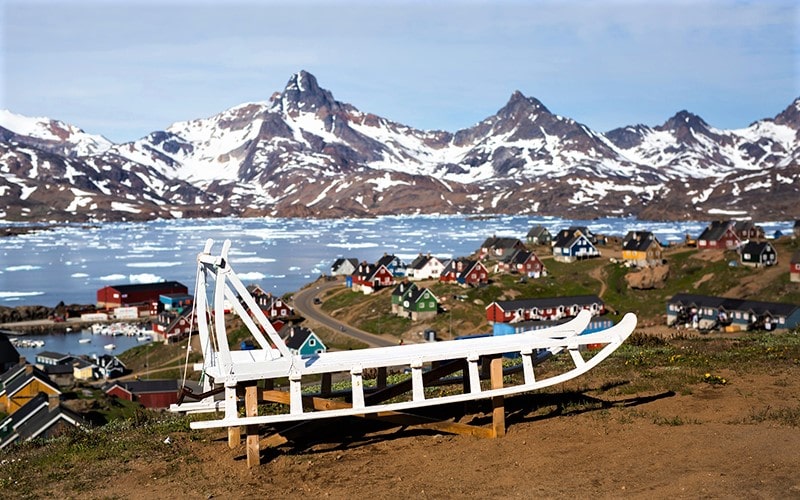 سورتمه چوبی در کنار خانه‌های گرینلند