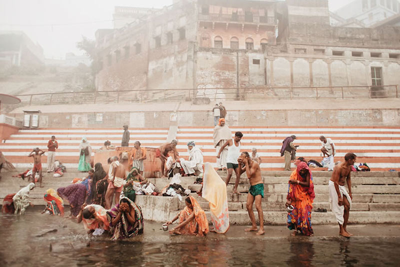 شستشوی مردم در کنار یک رودخانه مقدس در هند