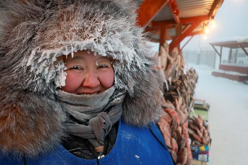 فروشنده‌ای در بازار فضای باز در دمای منفی ۵۰ درجه در شمال شرقی سیبری در روسیه؛ منبع عکس: Reuters؛ عکاس: Roman Kutukov