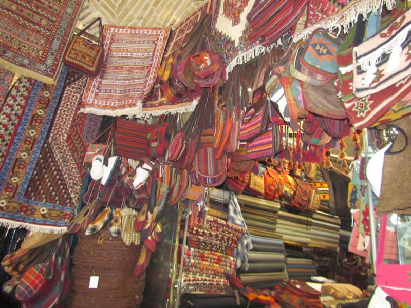 گلیم‌فروشی بازار کرمانشاه؛ منبع عکس: Apochi.com، عکاس: نامشخص