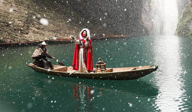 زنی در پالتوی قرمز بر قایقی روی آب