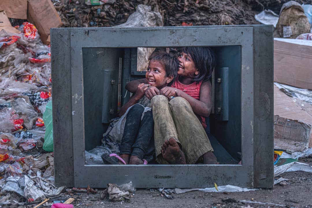 دو کودک نشسته در میان قاب یک تلویزیون خراب