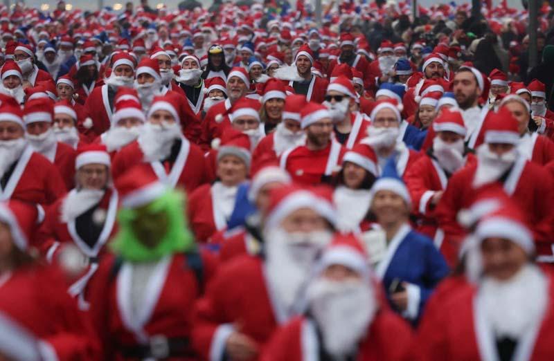 دوندگان با لباس بابانوئل در مسابقه سالانه دو پنج کیلومتر در لیورپول انگلستان؛ منبع عکس: Reuters؛ عکاس: Phil Noble