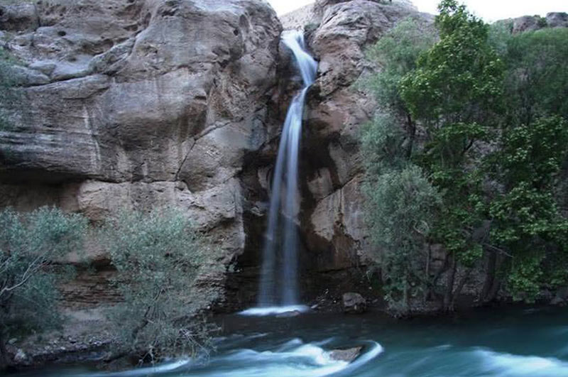 آبشار نوجان بین سنگ‌های بزرگ با حوضچه پایین آن، منبع عکس: مجله تاپ توریست، عکاس نامشخص