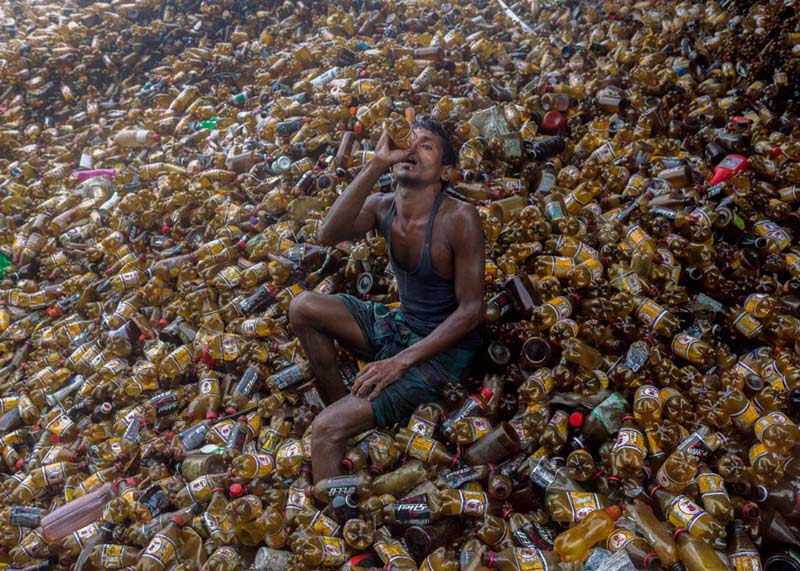 مرد بنگلادشی میان بطری‌های نوشابه 