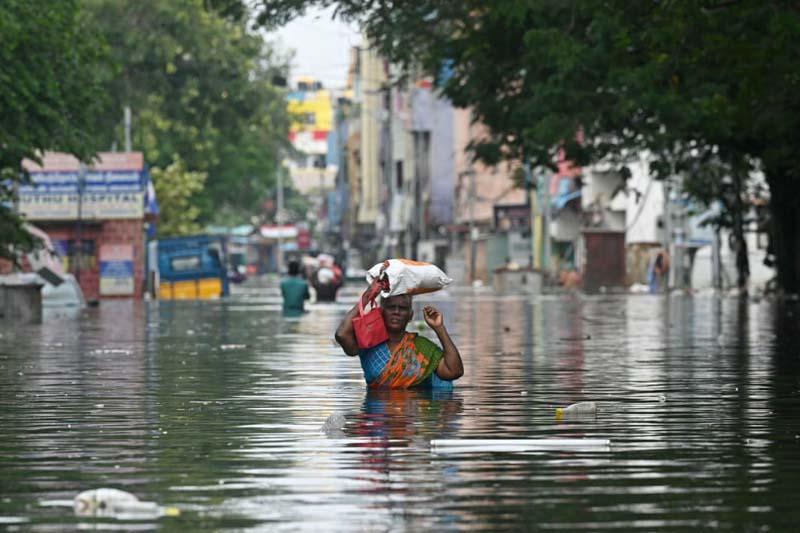 یک زنی پس از باران های شدید در خیابانی سیل زده در جنوب شرقی هند؛ منبع عکس: Getty Images؛ عکاس: نامشخص