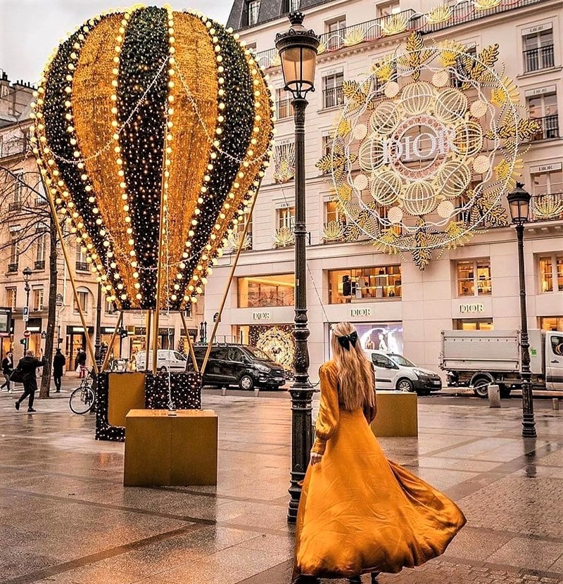 دختری با لباس خردلی در نزدیکی بالون کریسمس در پاریس