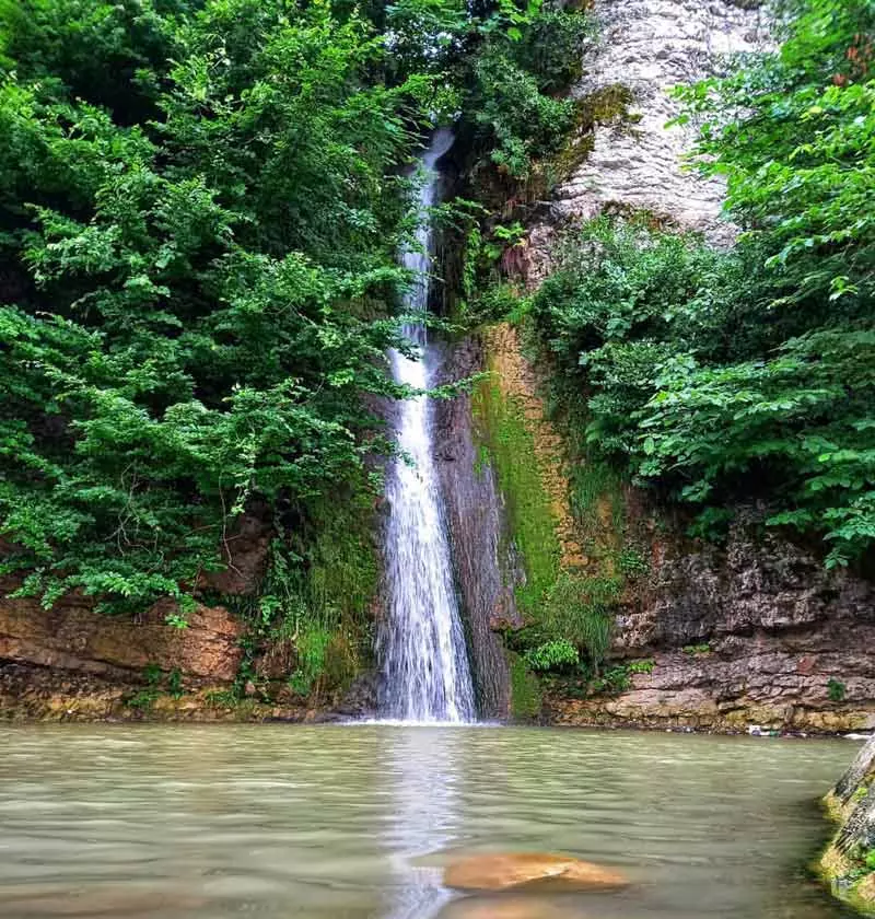 آبشار سینوا در فصل بهار با منظره رودخانه زیر آن و بوته های سرسبز، منبع عکس: صفحه اینستاگرام lemraaski، عکاس نامشخص