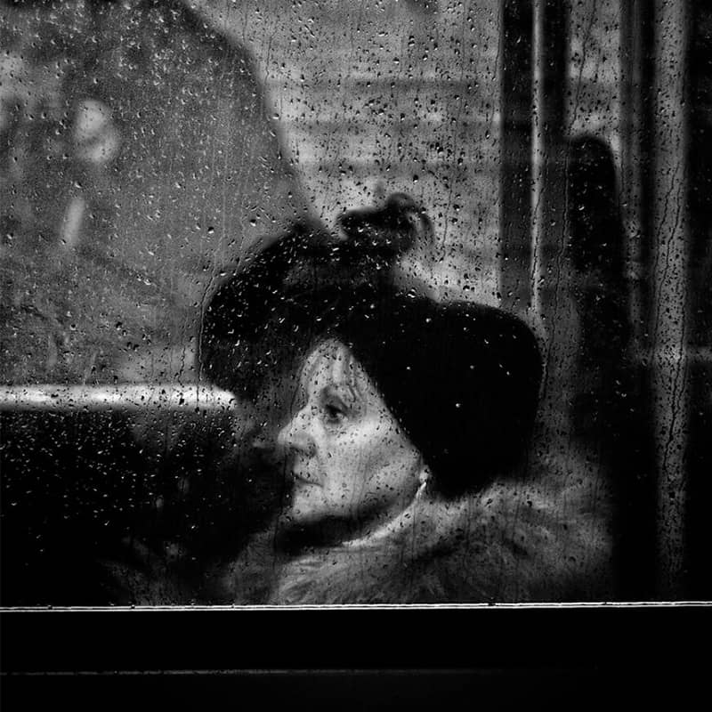 عکس سیاه و سفید از زنی سالخورده در هوای بارانی