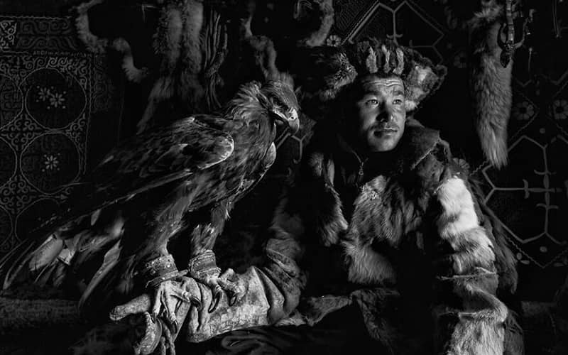 شکارچی قزاق همراه با عقابش در عکسی سیاه و سفید
