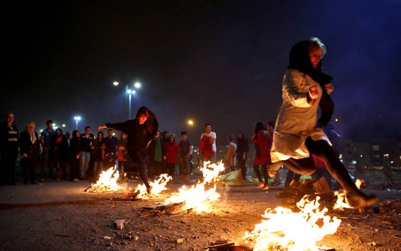 چند زن در حال پریدن از روی آتش در چهارشنبه سوری