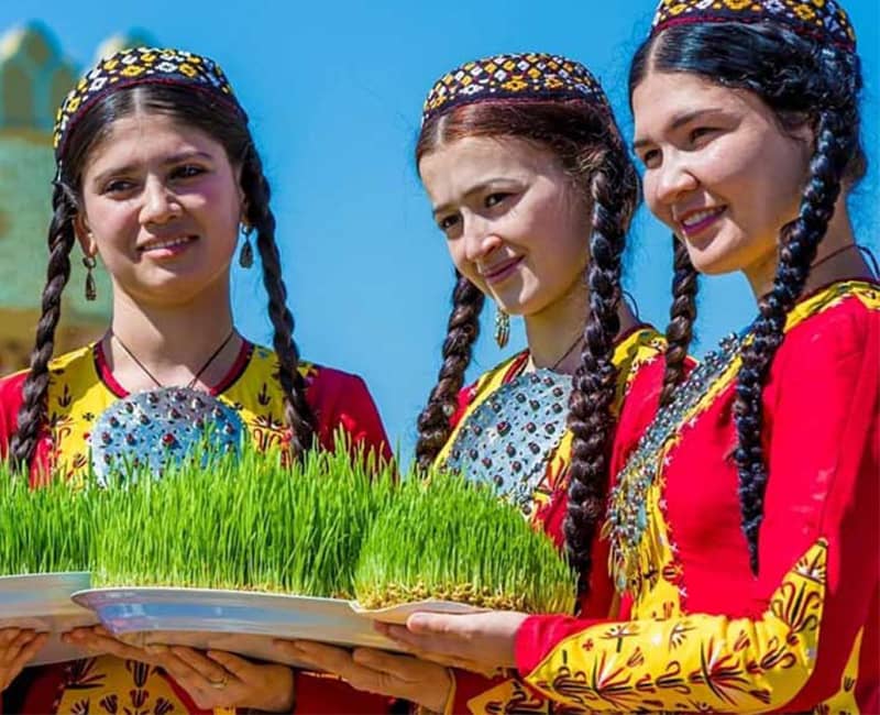 سه دختر با لباس سنتی و سبزه عید در دست