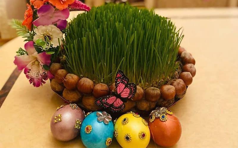 چهار تخم مرغ رنگی در کنار سبزه عید