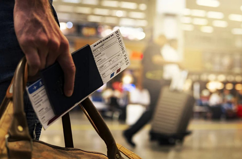 مسافر با پاسپورت و بلیط در فرودگاه