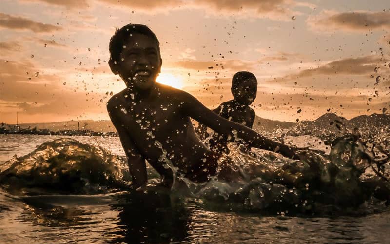 دو کودک مشغول آب بازی در دریا