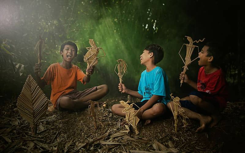 سه پسربچه در حال ساخت کاردستی در طبیعت