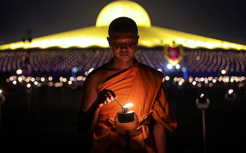 راهبی در حال روشن کردن شمع