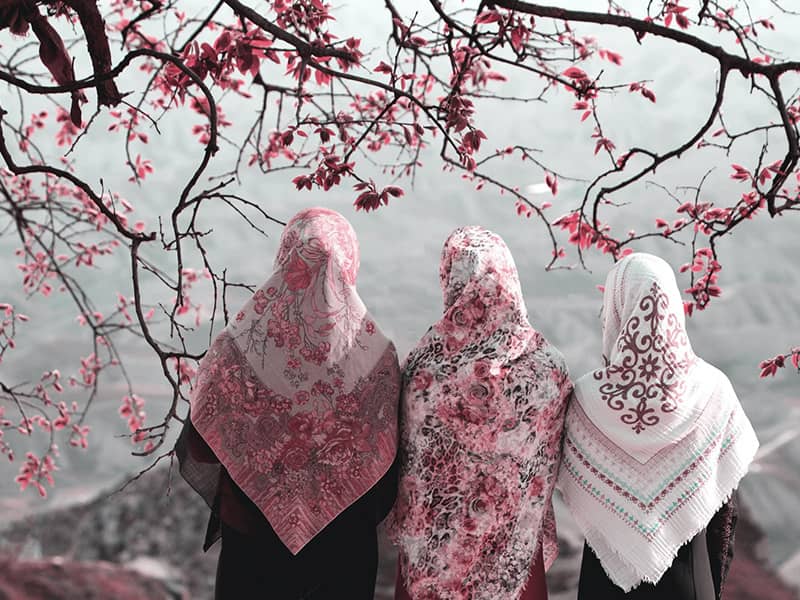سه زن در کنار درختی با شکوفه های بهاری