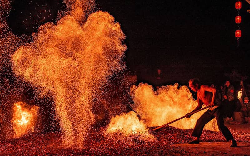 مردی در حال ریختن خاک روی آتش