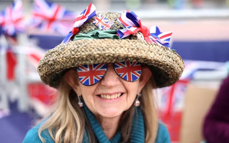 رنی با عینک و پرچم انگلیس در مراسم تاجگذاری شاه انکلیس