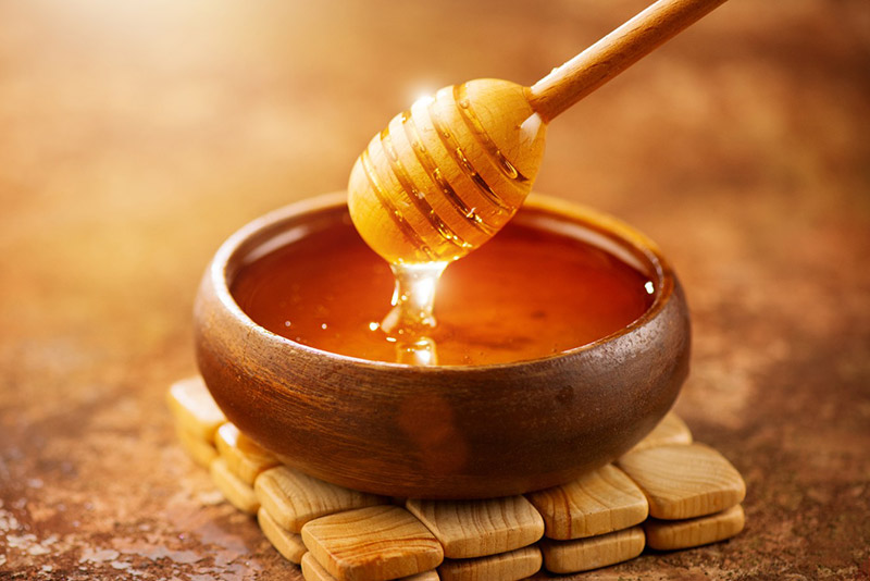 کاسه چوبی حاوی شیره عسل 