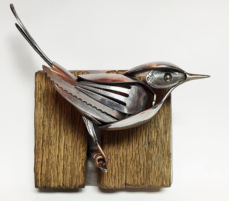 پرنده فلزی روی چوب