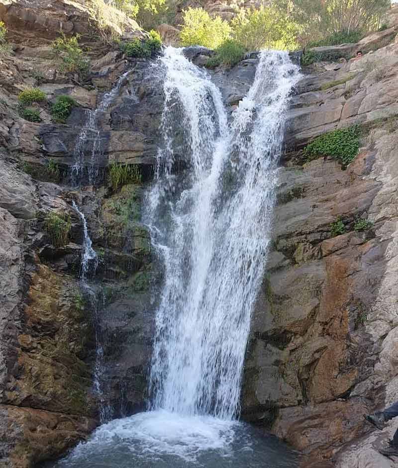 آبشار برگ جهان میان صخره های بلند کوهستان