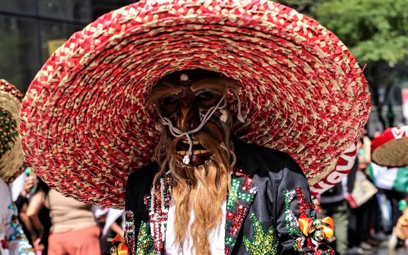 مردی با ماسک و کلاه در یک جشنواره