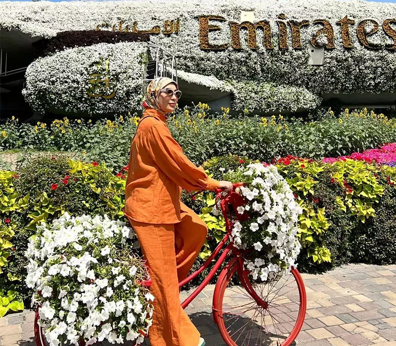 زنی سوار بر دوچرخه گل در باغ معجزه دبی، منبع عکس: اینستاگرام raykhonulasenova-official@